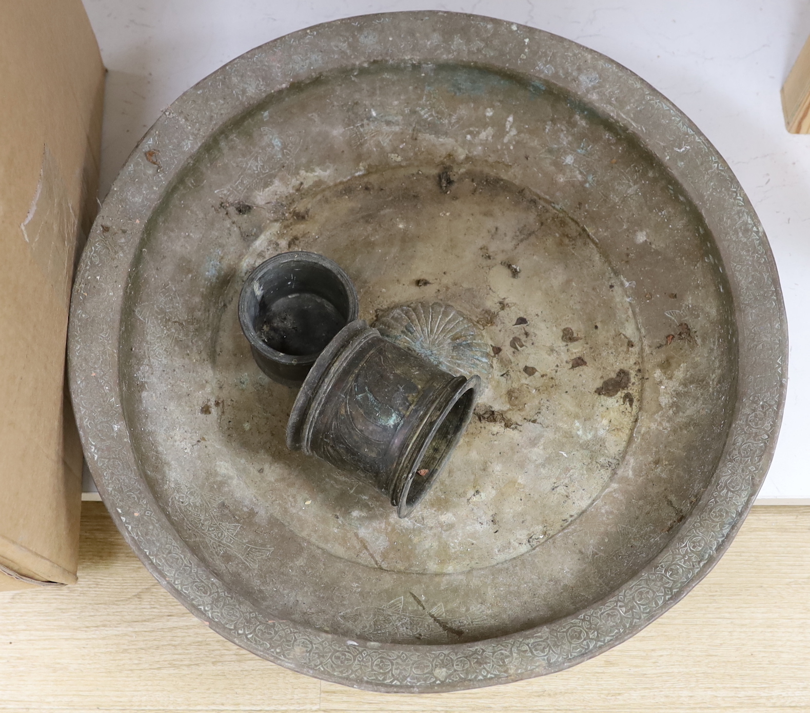 A group of 19th and early 20th century Indian brass and copper vessels, dishes, a vase, measures, etc. largest dish 46.5cm diameter